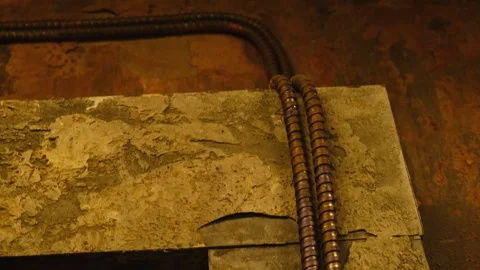 Close-up of two thick electrical cables running along a rough, worn-out concrete Video stock 297389600