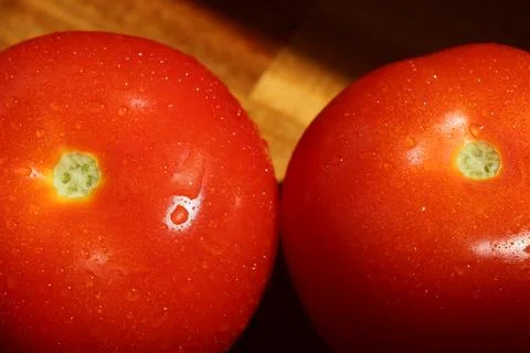 Close up of two tomatoes side by side on cutting board Stock Photos
