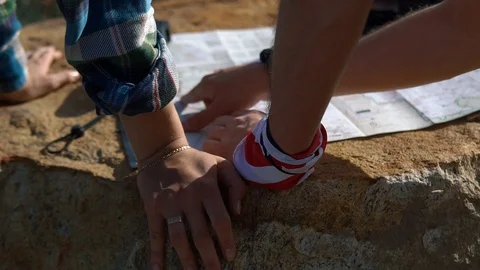 Close-up of two tourists a man and a woman with backpacks reading a map and look Stock Footage 101631967