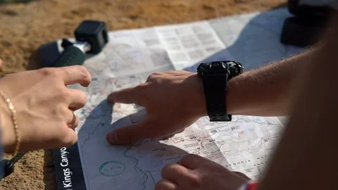 Close-up of two tourists a man and a woman with backpacks reading a map and look Stock Footage 119246434