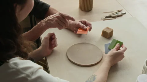 Close up of Two Unrecognizable Women Choosing Color for Their Pottery project Stock Footage 331803928
