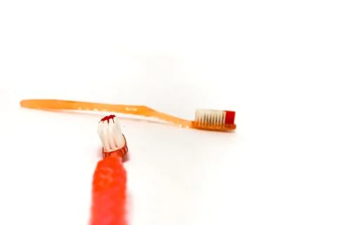 Close-up of two used toothbrushes with worn bristles on a white background,.. Stock Photos