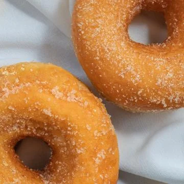 Close-up of two vanilla sugar donuts on a white tablecloth 스톡 사진