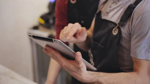 Close up of two waiters hands using digital tablet in cafe Video stock 88557867