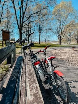 Close-up of two walking black bicycles with a basket parked to a pillar in the Stock Photos