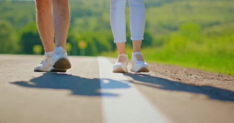 Close-up of two walking in sneakers on the road. Feet walking on the roadway Stock Footage 134575676