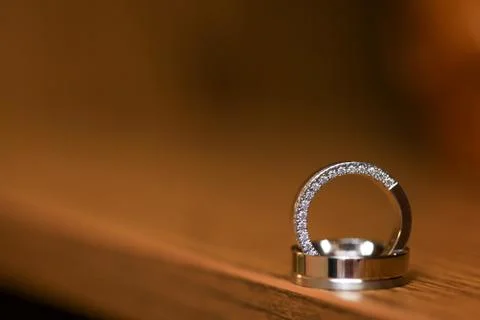 Close up of two wedding rings on flat wooden surface Foto stock