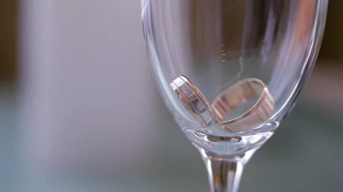Close-up two wedding rings in a glass of champagne. Stock Footage 101154343