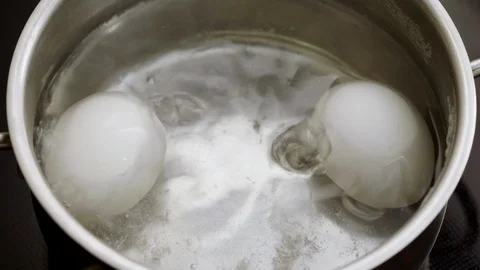 Close-up of two white chicken eggs in a pan of boiling water. 4K Stock Footage 122839060