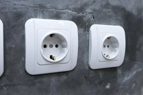 Close-up of two white electrical power sockets mounted on a raw polished co.. Stock Photos