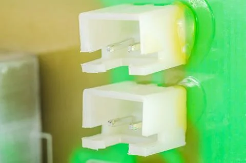 Close-up of two white plastic electrical connectors with metal pins on a gr.. Stock Photos