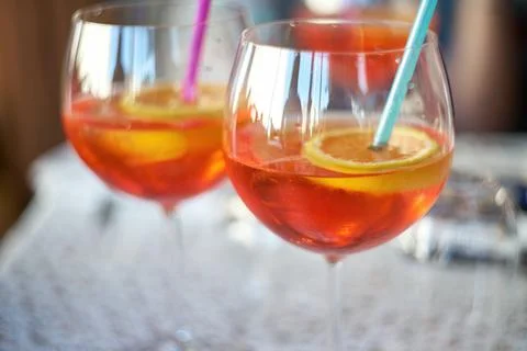 Close-up of two wine glasses filled with orange aperitif cocktail garnished.. Stock Photos