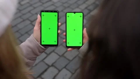 Close up of a two woman's hand holding a mobile telephone with a vertical green Stock Footage 135616861