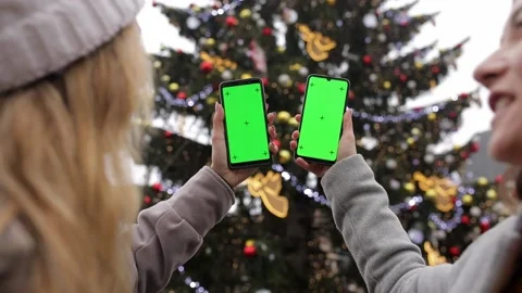 Close up of two a woman's hand holding a mobile telephone with a vertical green Stock Footage 135616871