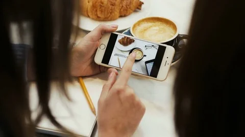Close-up of two women hands looking photo on smartphone in the cafe Stock Footage 72361908