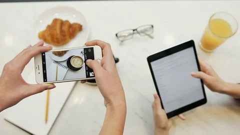 Close-up of two women hands taking photos of food and using tablet computer in Video stock 72361828