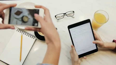 Close-up of two women hands taking photos of food and using tablet computer Stock Footage 72361893