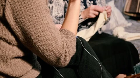 Close-up of two women's hands knitting cozy handmade items with yarn and needles Stock Footage 317485684