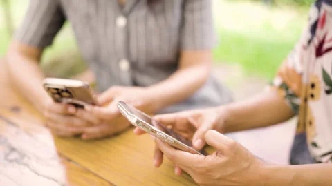 Close-up of two women's hands sitting and talking with friends. In the backyard  Video stock 252426094