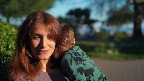 Close-up of a two-year-old little son in his arms and a young mother. The boy Stock Footage 118552080