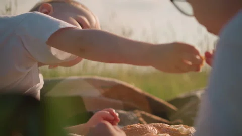 Close-Up of Two Young Boys Sharing Bread in a Grassy Field Stock Footage 283294061