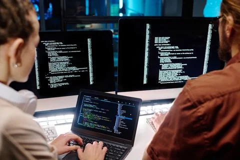 Close-up of two young developers working over data decoding software Stock Photos