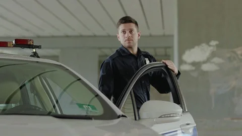 Close up two young men cops stand near patrol car go enforcement officer police Stock Footage 112957410