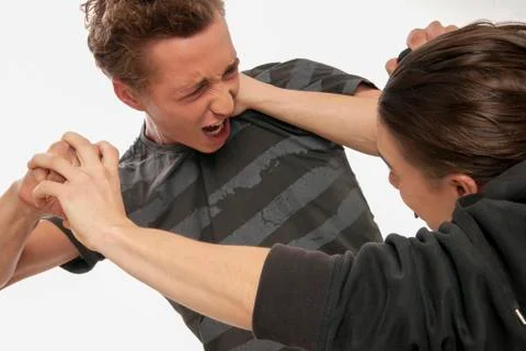 Close-up of two young men fighting, studio shot on white background 写真素材
