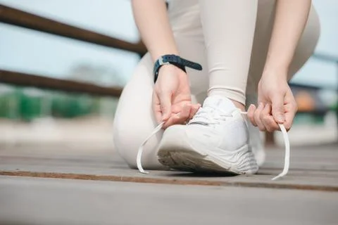 Close up tying sneaker running jogging laces on wooden path during outdoor .. Stock Photos