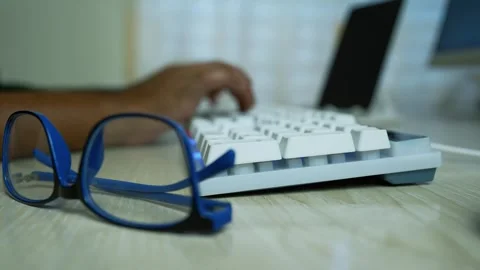 Close-up of typing hands and glasses on a desk Stock Footage 316901986