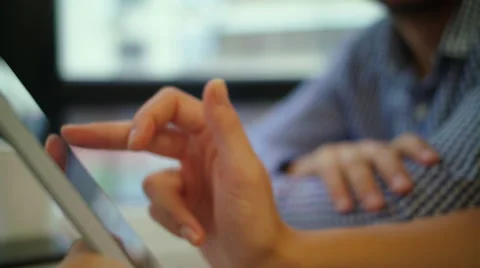 Close up typing on her tablet.Smiling young handsome businessman holding cup of Stock Footage 68897151