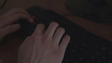 Close up typing on a keyboard with black and red keys. Generic wood desk. Stock Footage 88708662