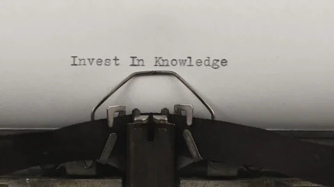 Close-up typing a quote invest in knowledge, old vintage typewriter Stock Footage 122332294
