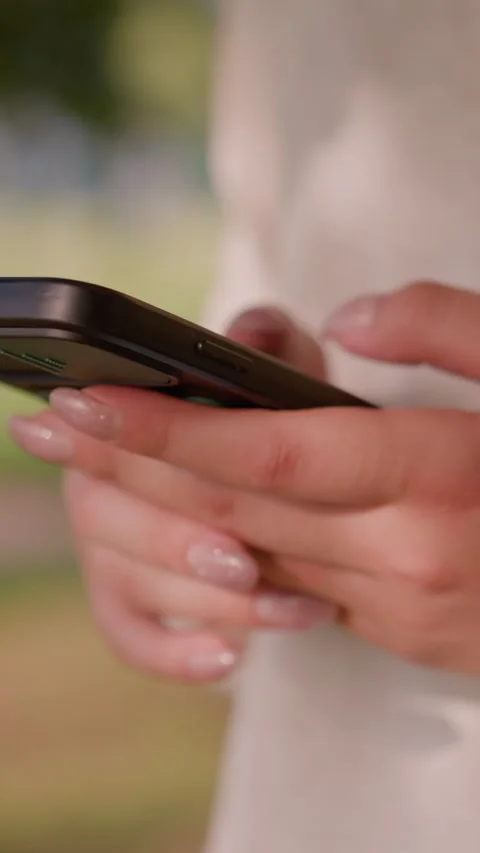 Close-Up of Typing on Smartphone with Polished Nails and Blurred Green Stock-Footage 310412420