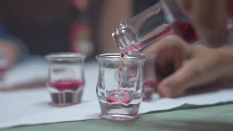 Close up tyrolean red Schnaps being poured into a small glass from a Stock Footage 198320014