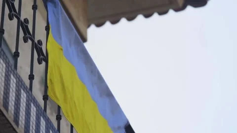 Close Up of an Ukrainian Flag Hanged on a Balcony With a Misty Sky Video stock 213977296