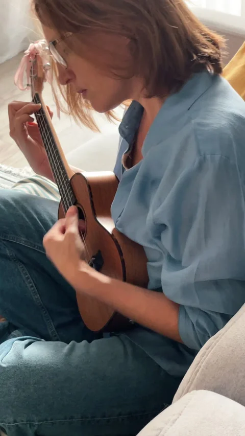 Close up ukulele string instrument being played by woman during music lesson at Vidéo 315370255