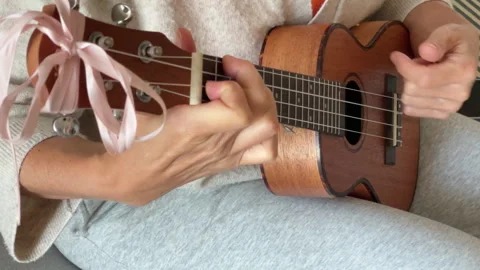 Close up ukulele string instrument popular on Hawaii islands. Woman playing nylo Stock Footage 329786854