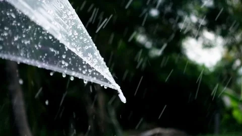 Close-up on umbrella with rain falling in slow motion shot Stockbeeldmateriaal 77174623