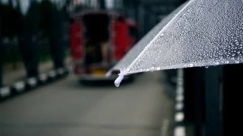Close-up on umbrella with traffic in raining day Stock Footage 77174648