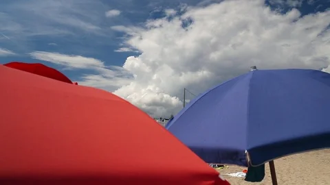 Close-up umbrellas at the beach with clouds background - climate change Stock Footage 94823691