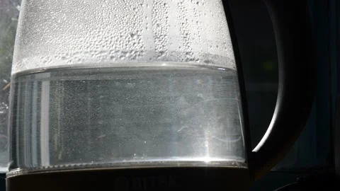 Close-up of uncleared boiling water in old transparent kettle with limescale Stock Footage 138227598