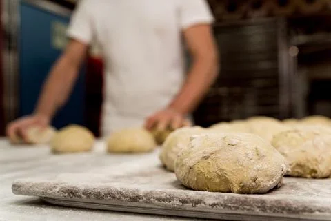 Close up of uncooked bread shapes of fresh dough with flour on shelf before e Stock Photos
