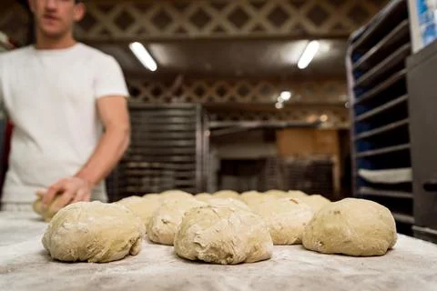 Close up of uncooked bread shapes of fresh dough with flour on shelf before e Stock Photos