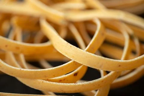 Close-up of uncooked ribbon pasta inside clear plastic. Stock Photos