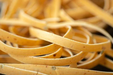 Close-up of uncooked ribbon pasta inside clear plastic. Stock Photos
