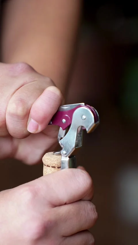 Close up of uncorking cork white wine bottle with corkscrew Stock Footage 327912624