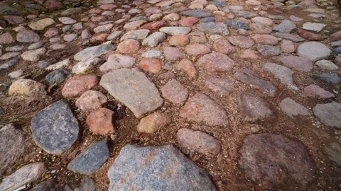 Close-up of uneven historic cobblestone ground with rounded fieldstones and Stock Footage 333411688
