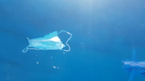 Close-up of a unfocused protective mask and glove floating in sea water. Stock-Footage 137687956