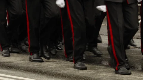 Close-up of uniformed personnel marching in formation on a wet street Stock Footage 335264451
